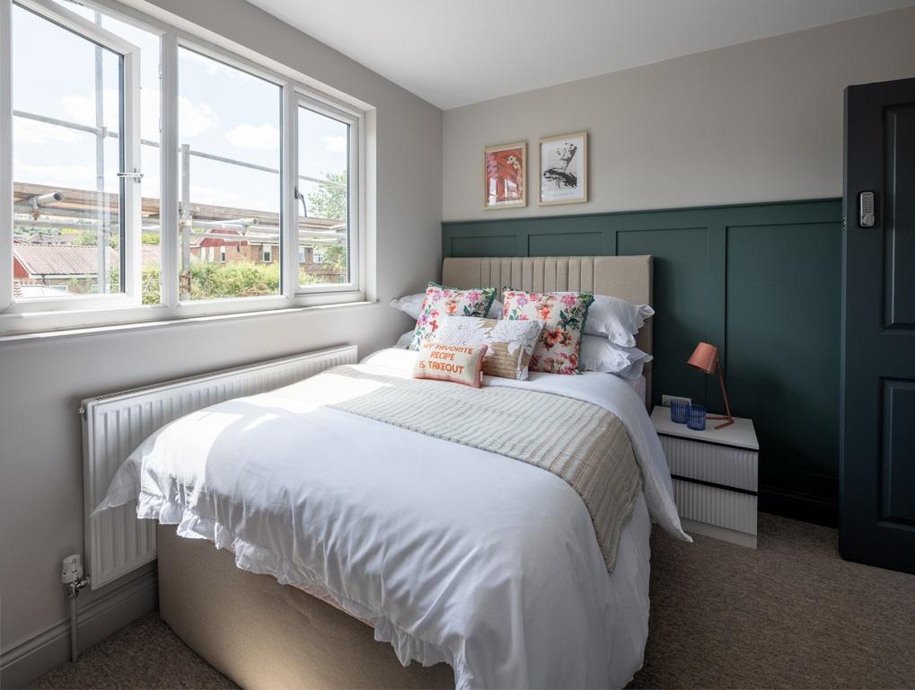 Bright, neatly styled double bedroom with a com...
