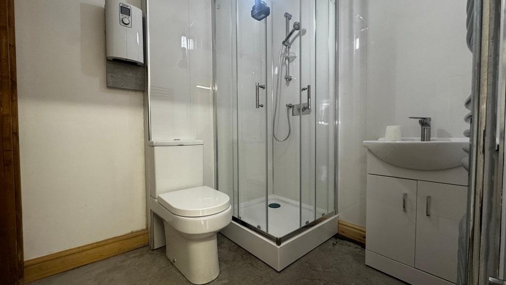Bright, modern bathroom with a corner glass sho...