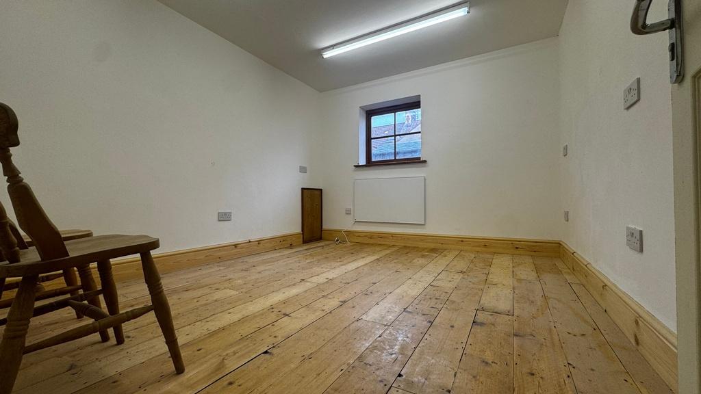 Simple, freshly painted single bedroom with war...