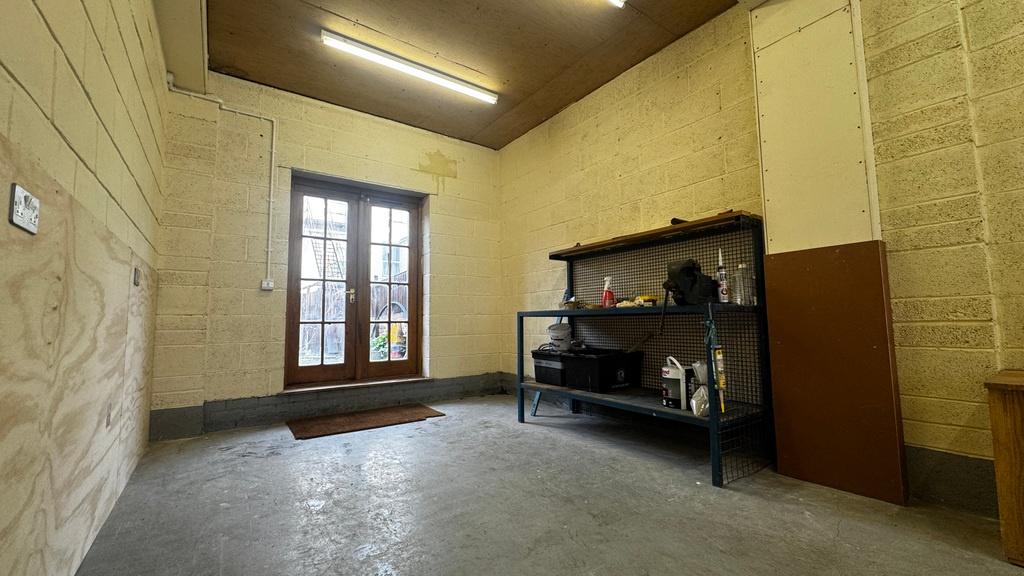 Well-lit utility/storage room with sturdy shelv...