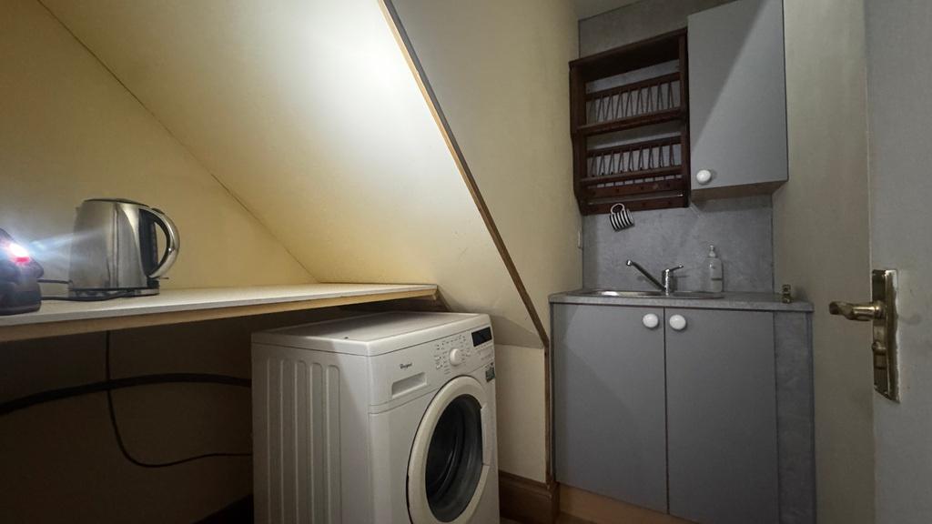 Compact utility-style kitchenette with a built-...