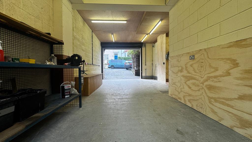 Long, well-lit garage/storage space with shelvi...