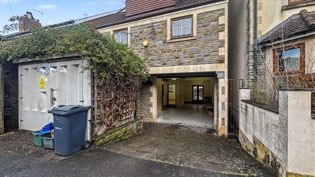 Covered driveway entrance to a stone-fronted pr...