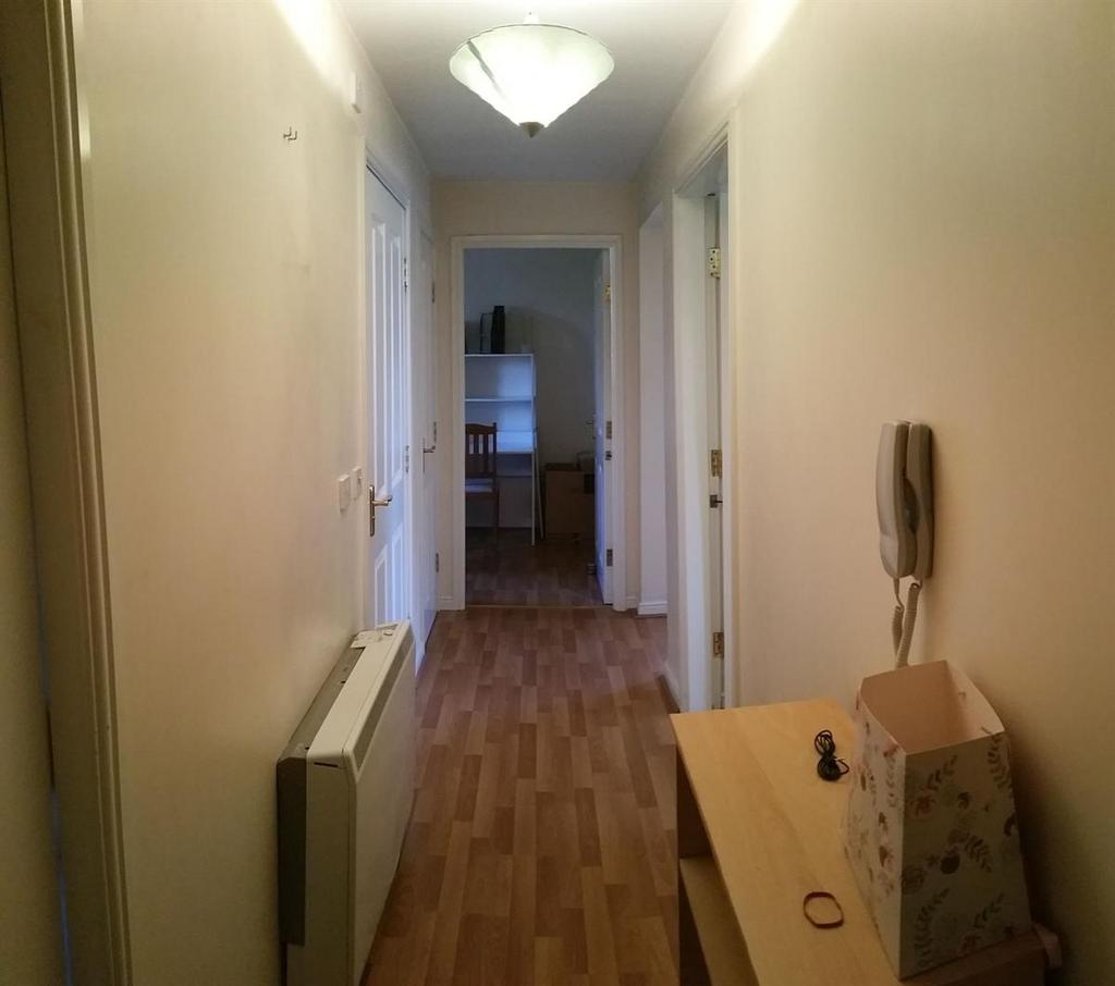 Bright, neutral hallway with wood-effect floori...