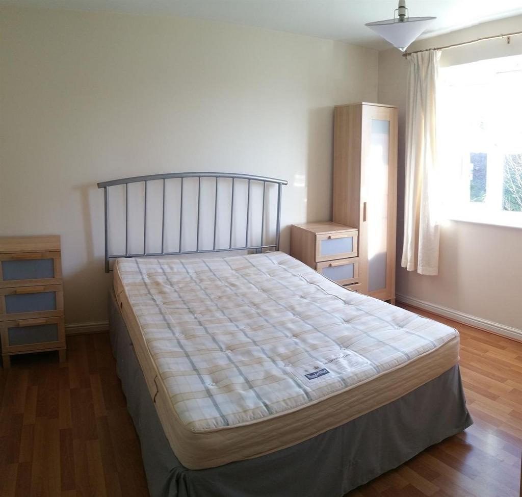 Bright, simply furnished bedroom with a double ...