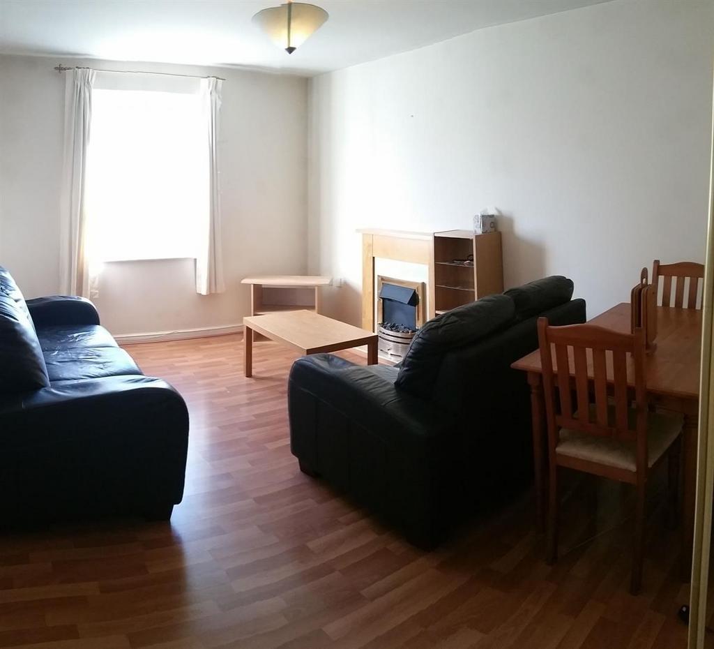 Bright, simply furnished living room with wood-...