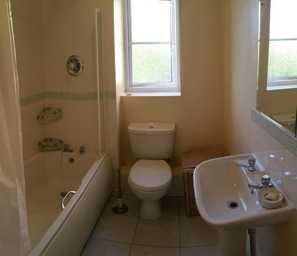 Bright bathroom with a classic white suite incl...
