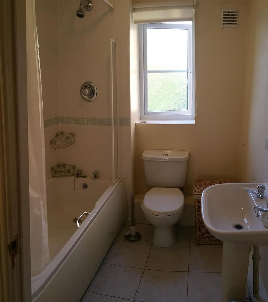 Bright, well-maintained bathroom with a bathtub...