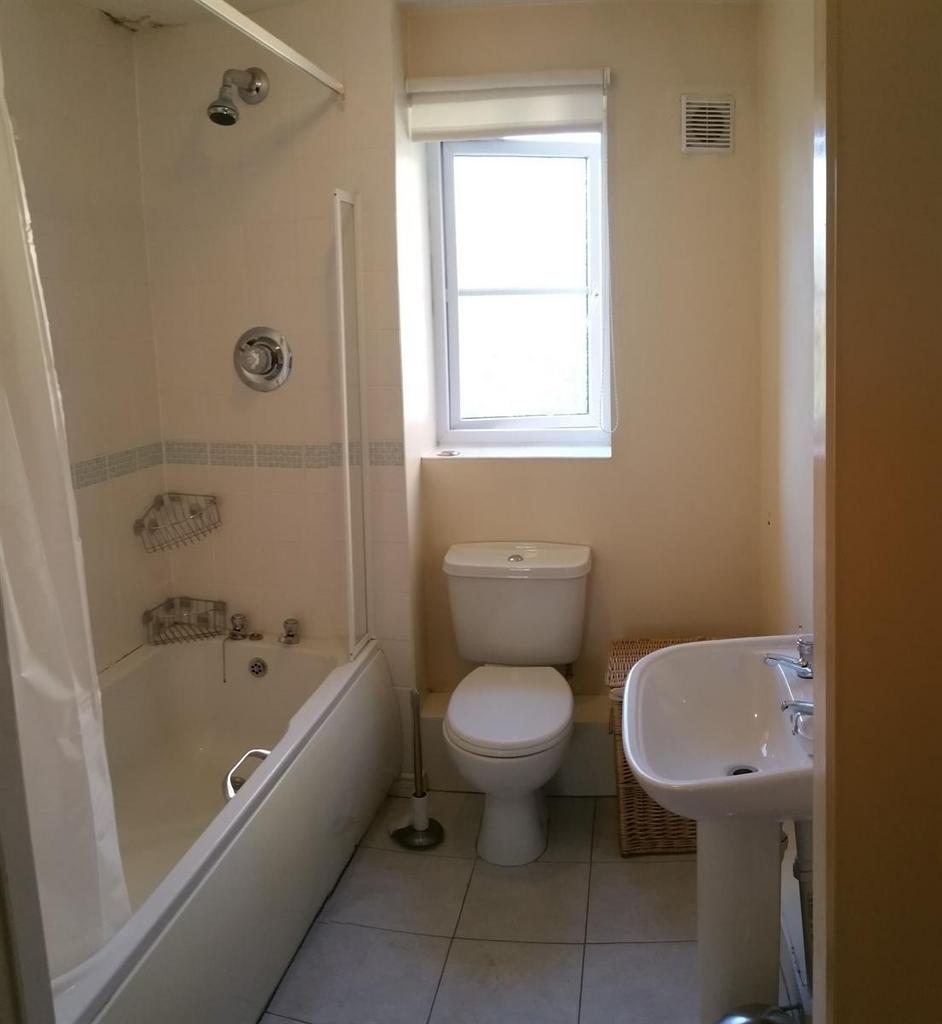 Bright, well-maintained bathroom with a bath an...