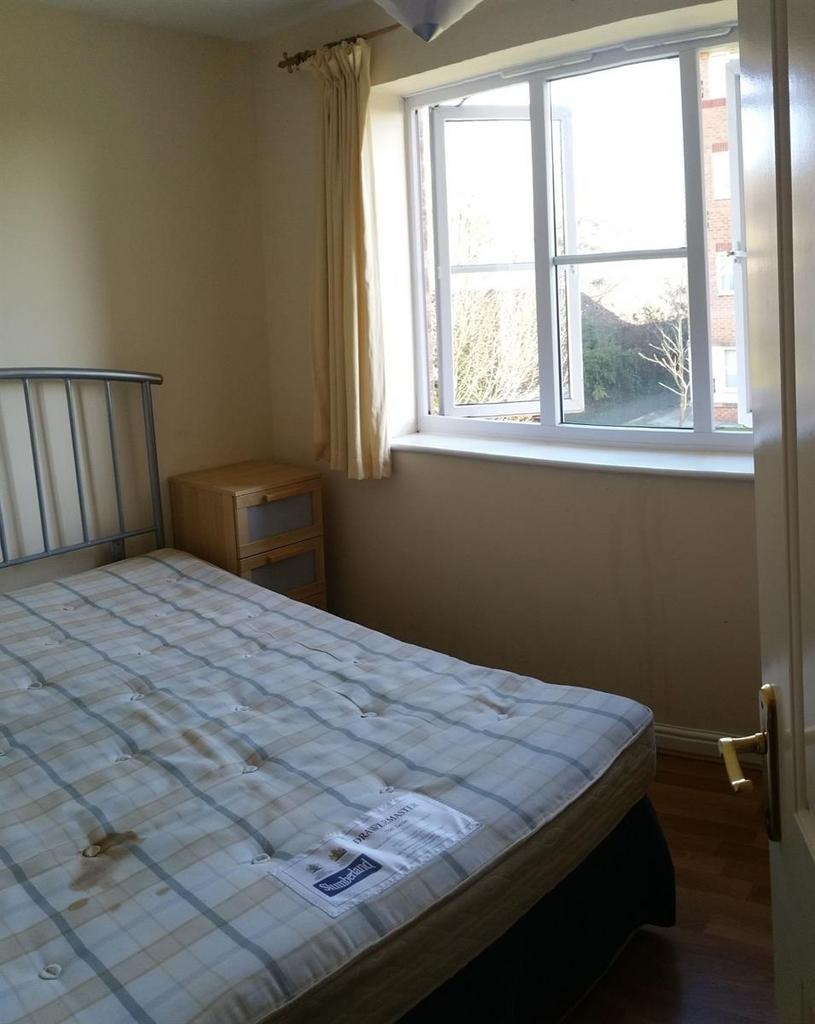 Bright double bedroom with a large window letti...