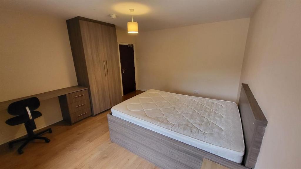 Bright, simply furnished bedroom featuring a do...