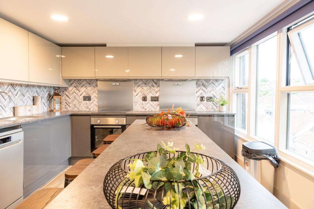Modern kitchen with a long central island, slee...
