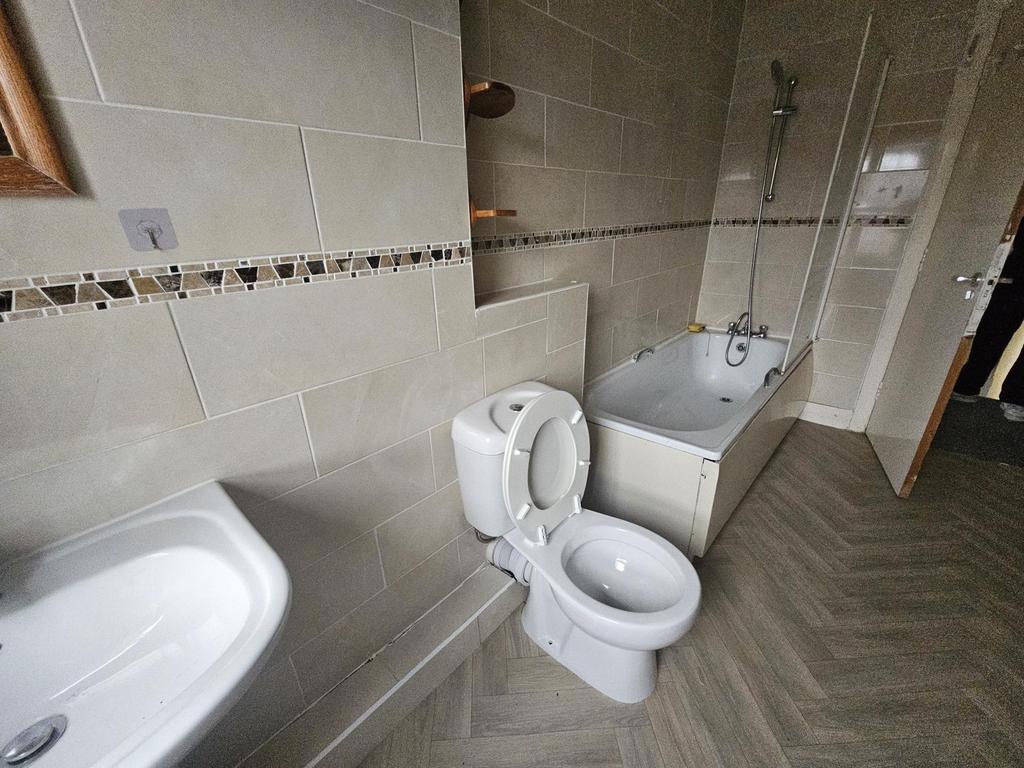 Modern bathroom with tiled walls and floor, fea...