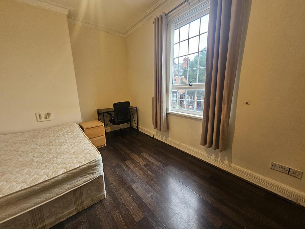 Bright, simply furnished bedroom with large win...