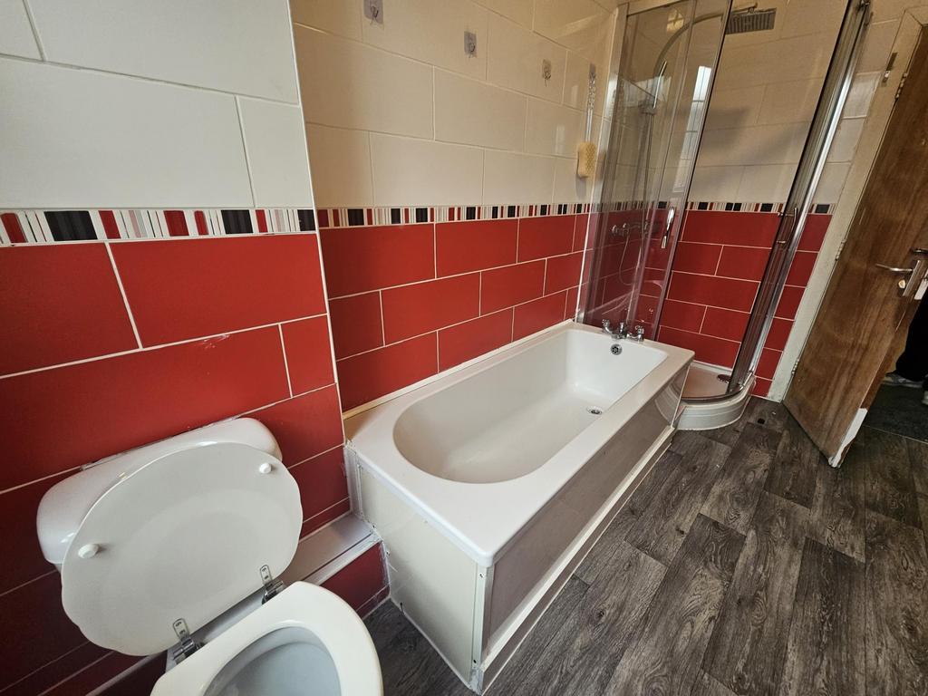 Modern bathroom with a white bath and glass sho...