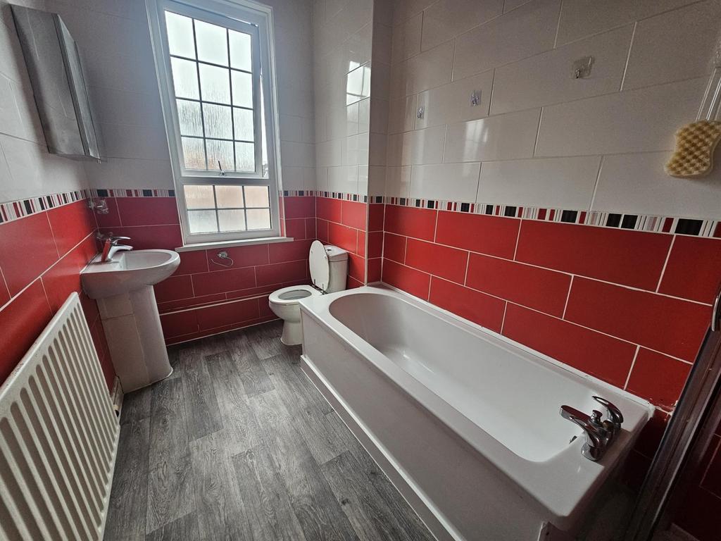 Bright bathroom with a full-size bathtub, pedes...
