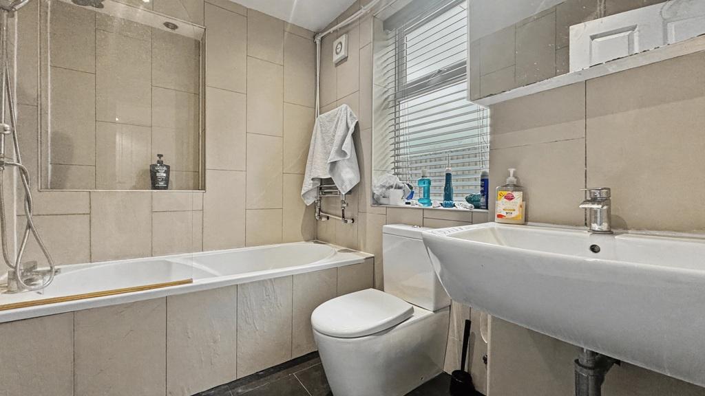Bright, modern bathroom with a built-in bath, c...