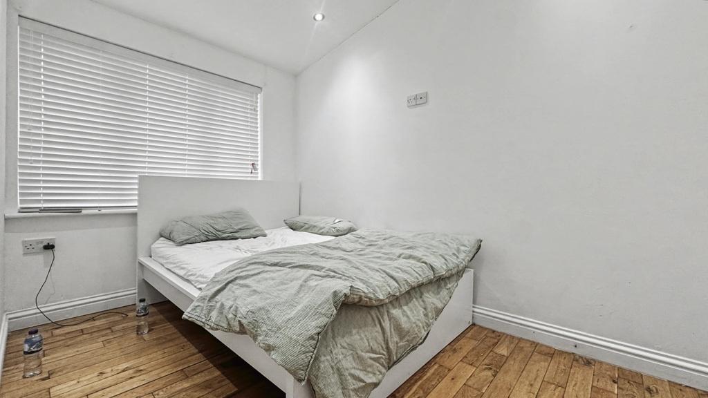 Bright, simply furnished bedroom with a neat si...