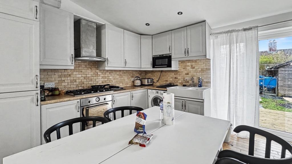 Bright modern kitchen with white cabinetry, int...