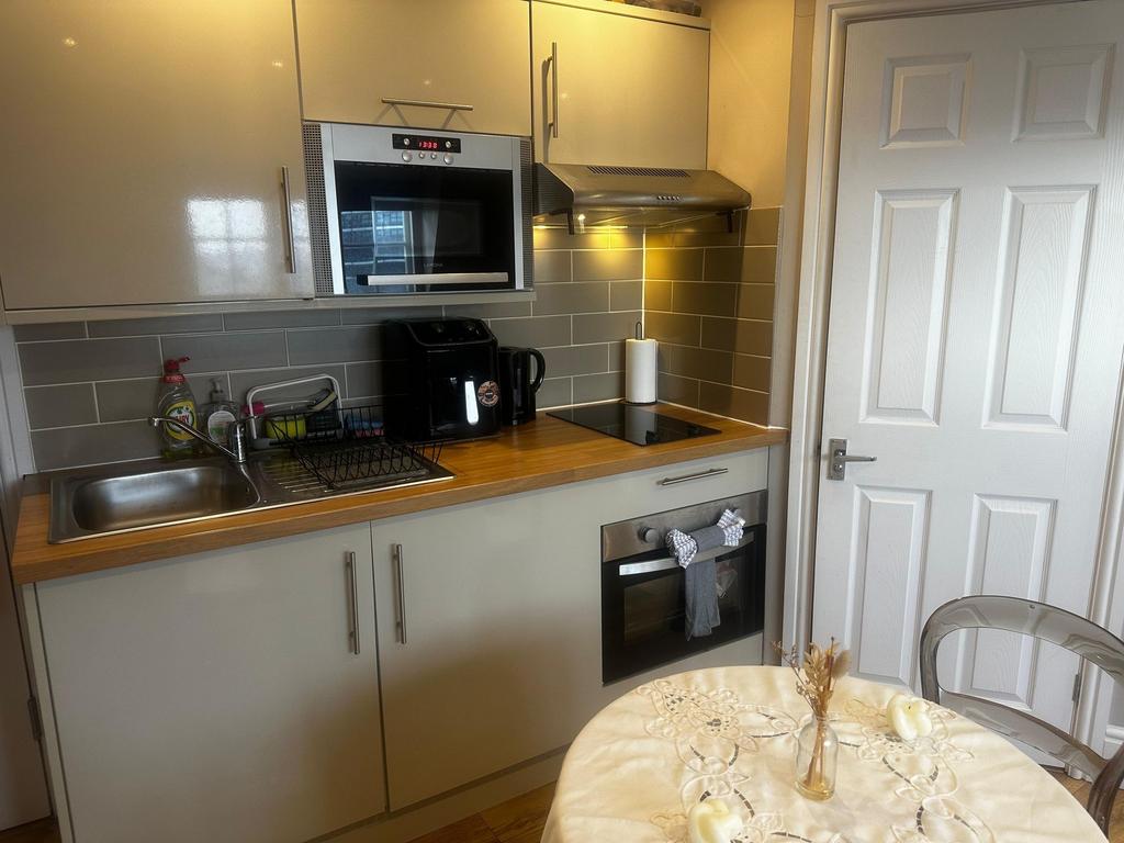 Modern compact kitchen with wood-effect worktop...
