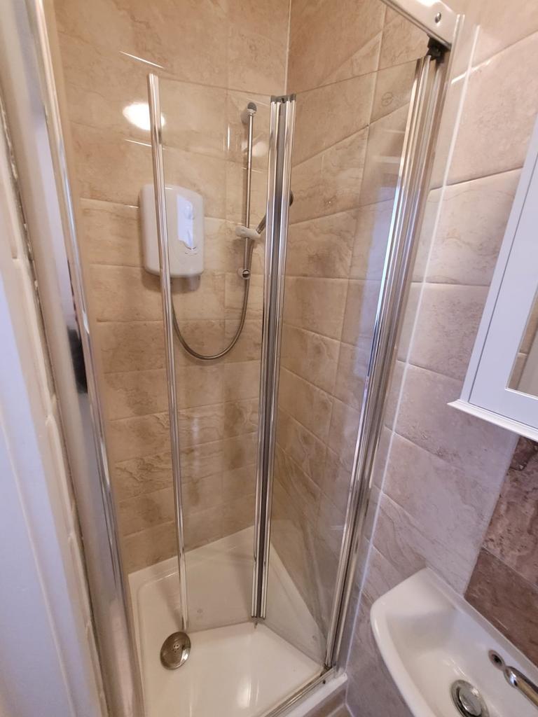 Compact, modern shower cubicle with tiled walls...