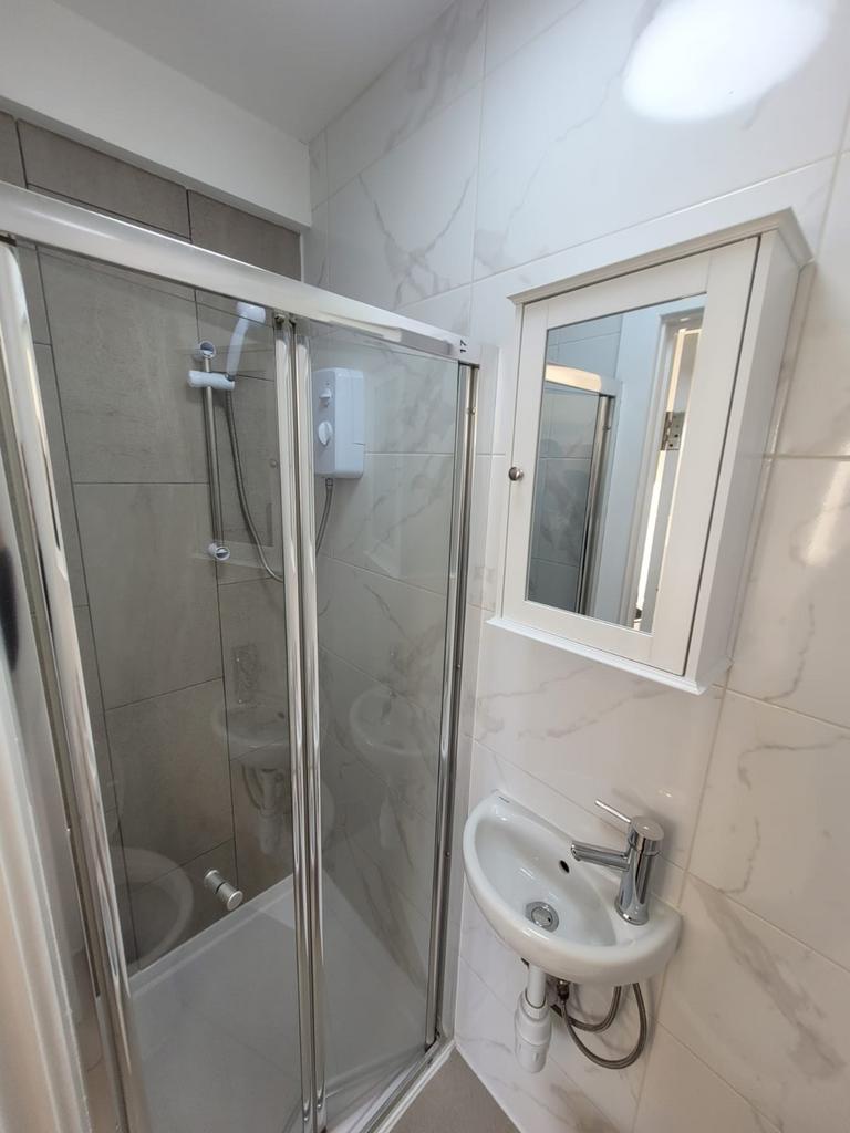Bright, modern bathroom featuring a glass-enclo...