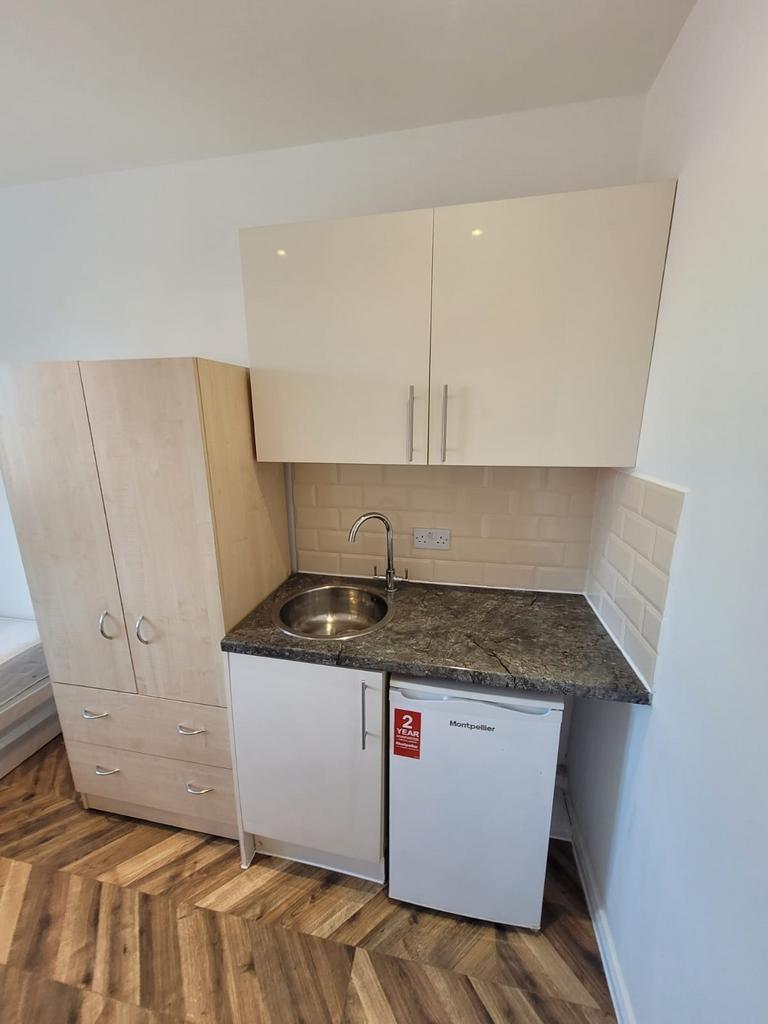Compact kitchenette with modern marble-effect c...