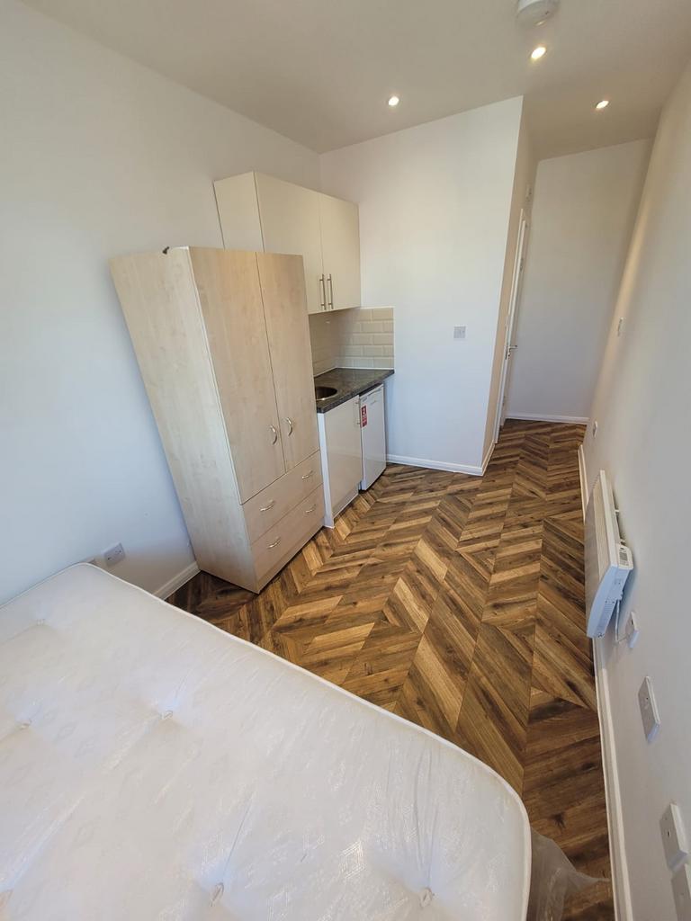 Compact furnished bedroom with a double bed, fi...