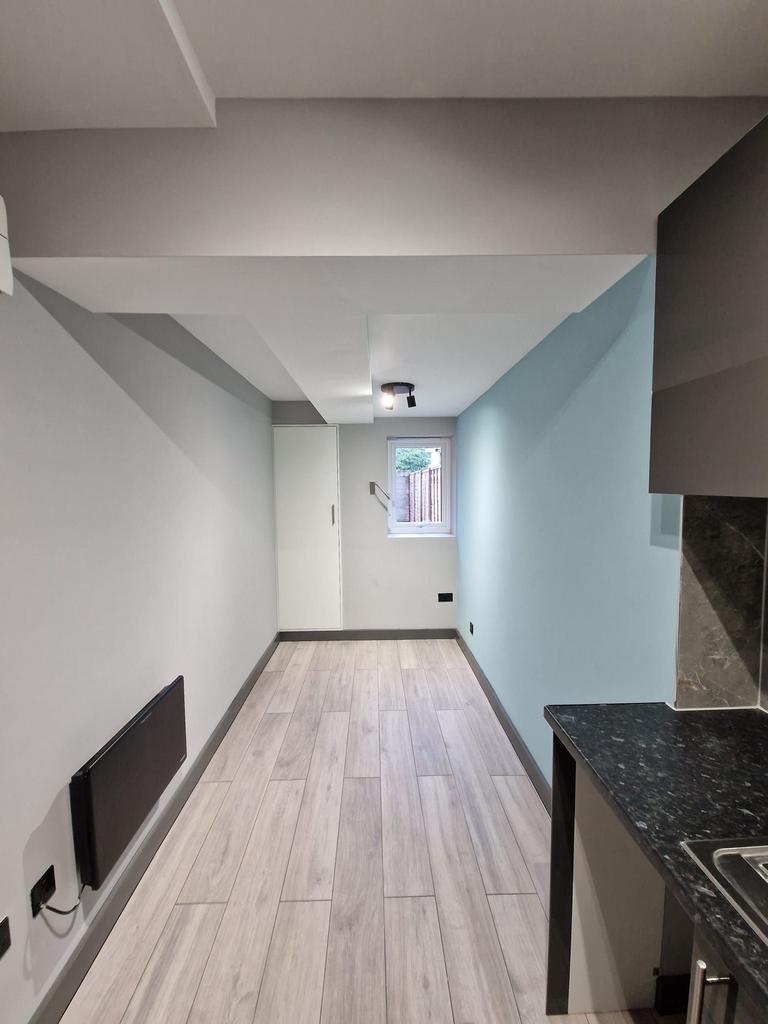 Long, modern kitchenette with wood-effect floor...
