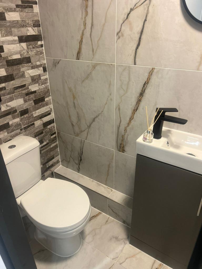 Contemporary WC with marble-effect tiles, sleek...