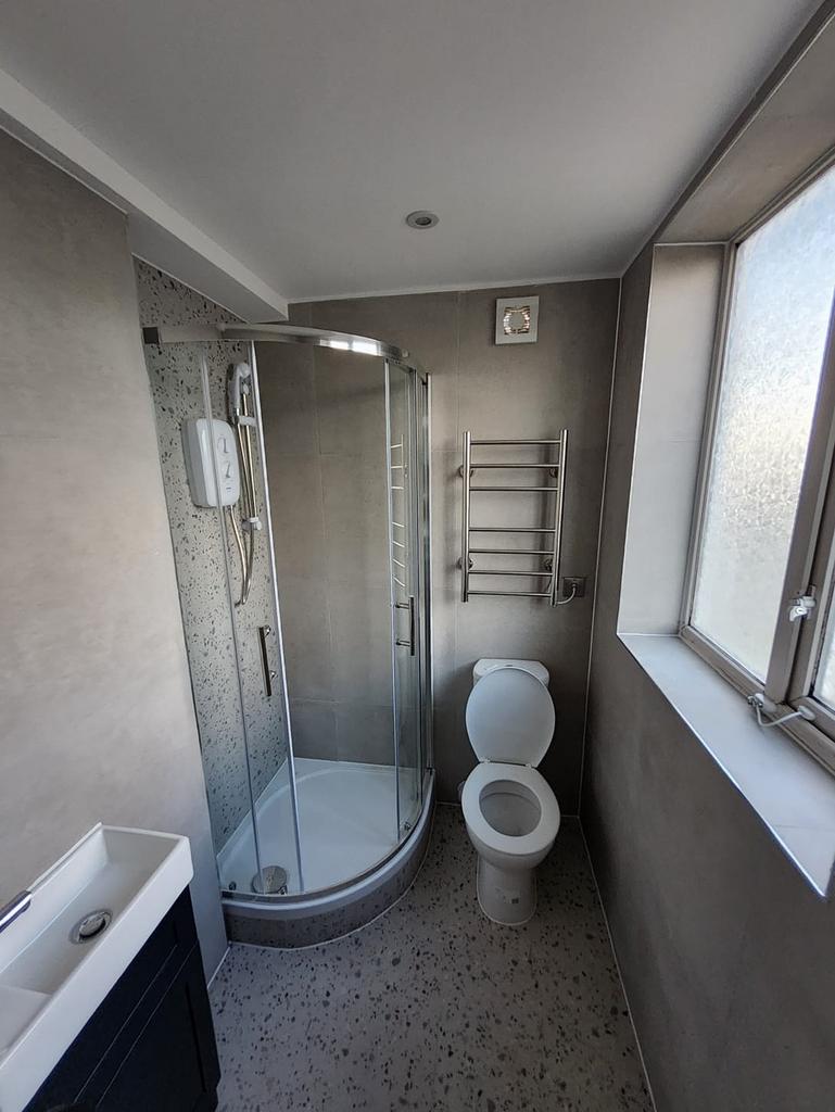 Modern bathroom with a curved glass shower encl...
