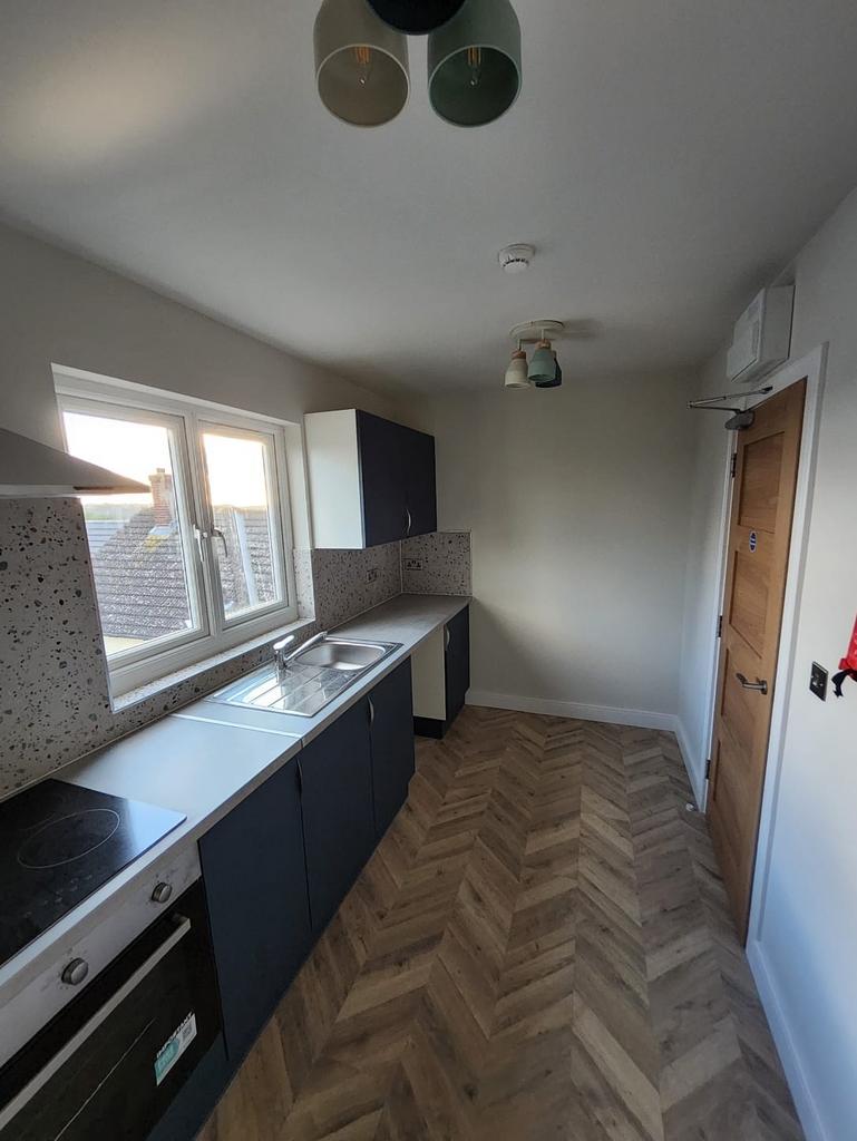 Bright, modern galley kitchen with a long count...