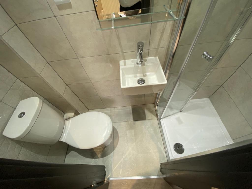 Modern tiled ensuite bathroom with a corner sho...