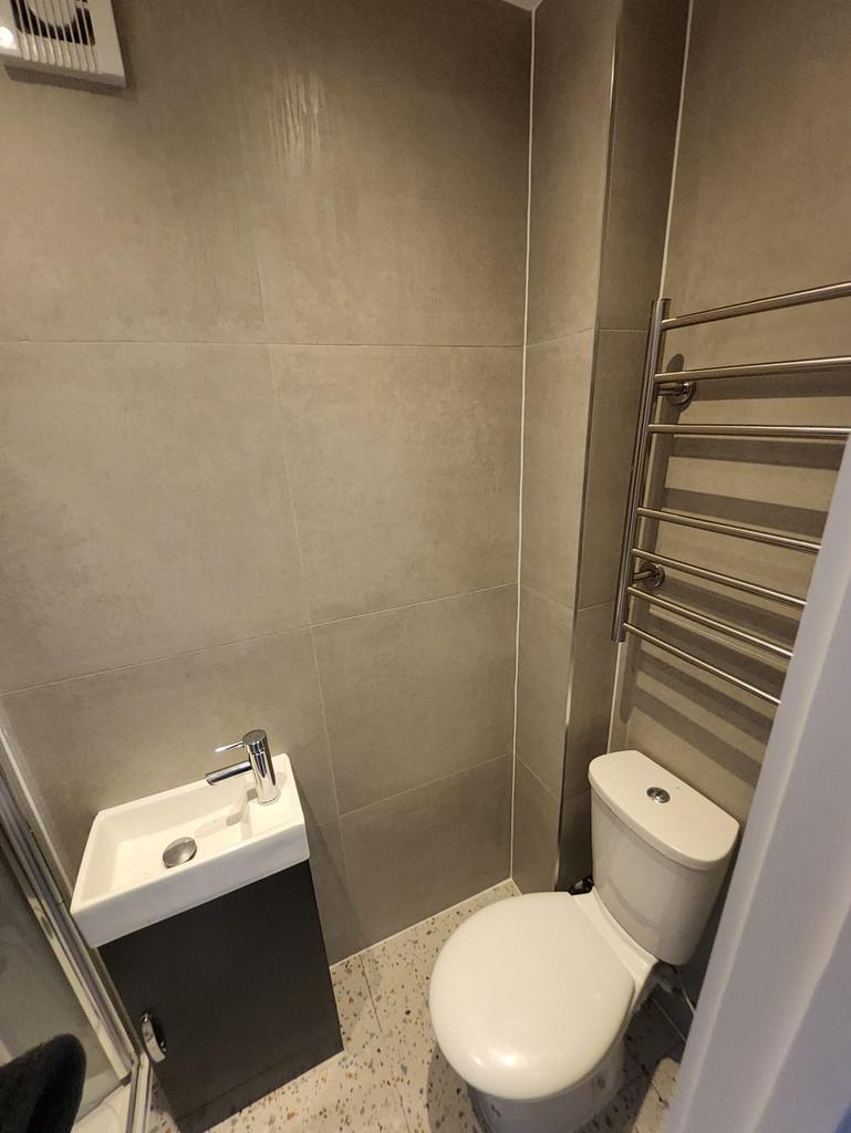 Compact modern bathroom with a sleek toilet, sm...