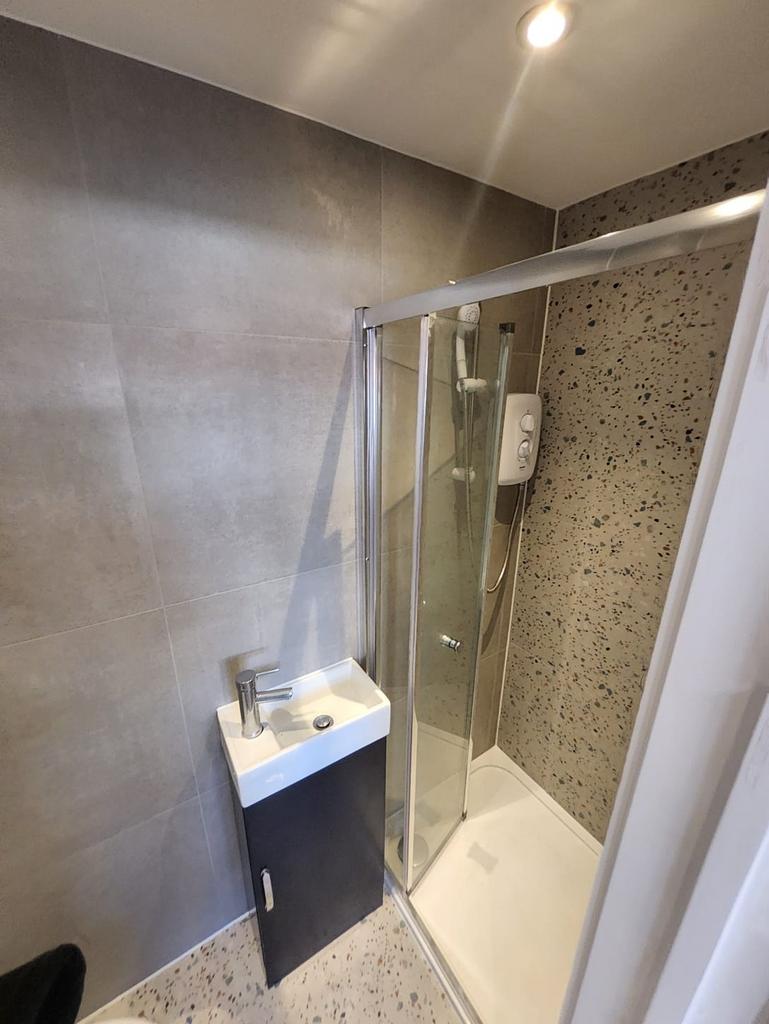 Modern tiled bathroom with a glazed shower encl...