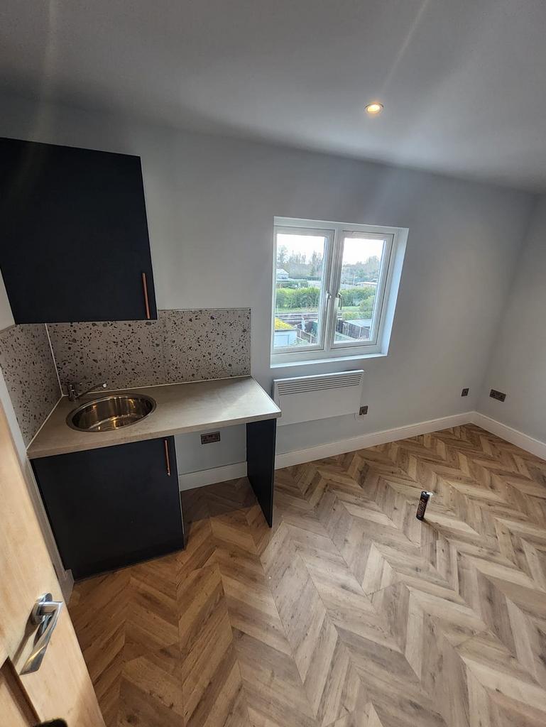 Bright, modern kitchenette with herringbone-sty...