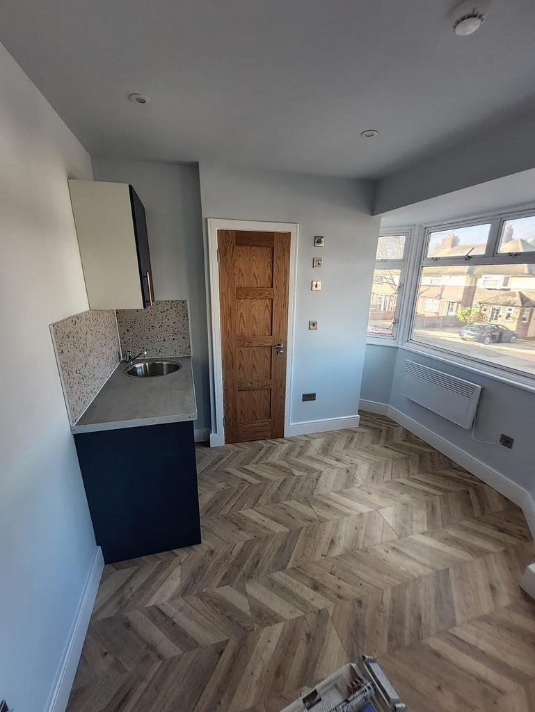 Bright compact kitchenette with a modern sink, ...