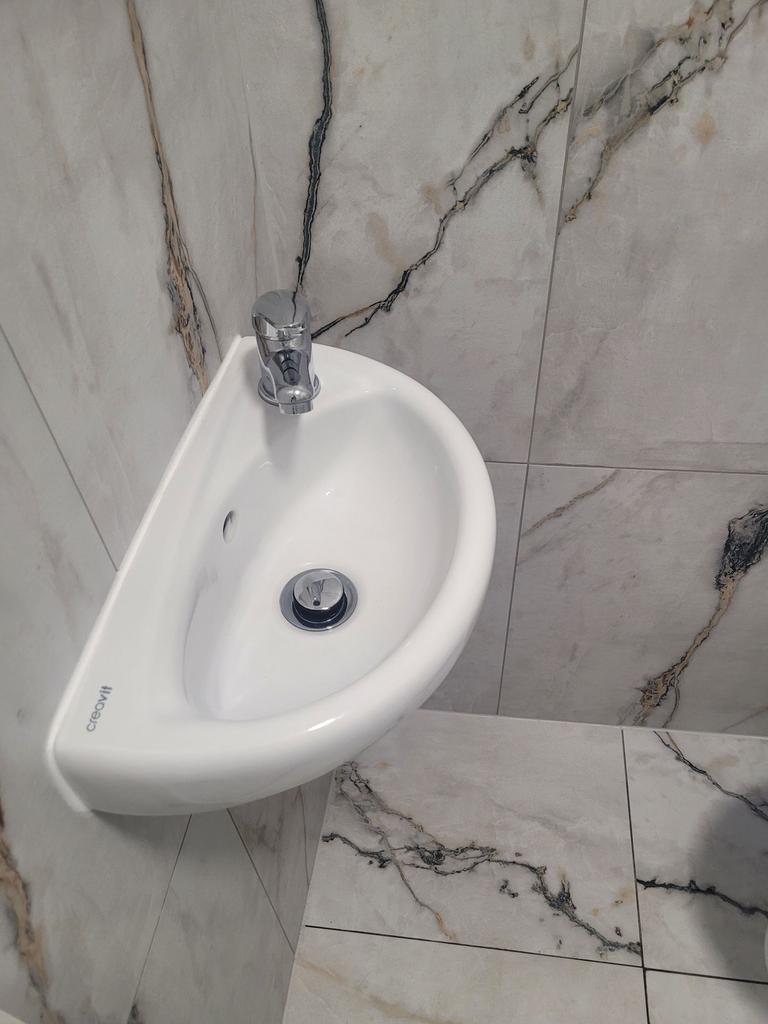 Compact modern cloakroom with a wall-mounted co...