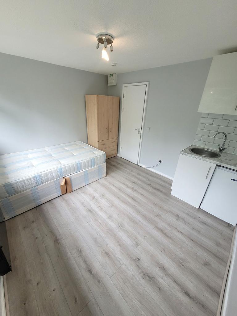 Bright, freshly painted single bedroom with lam...