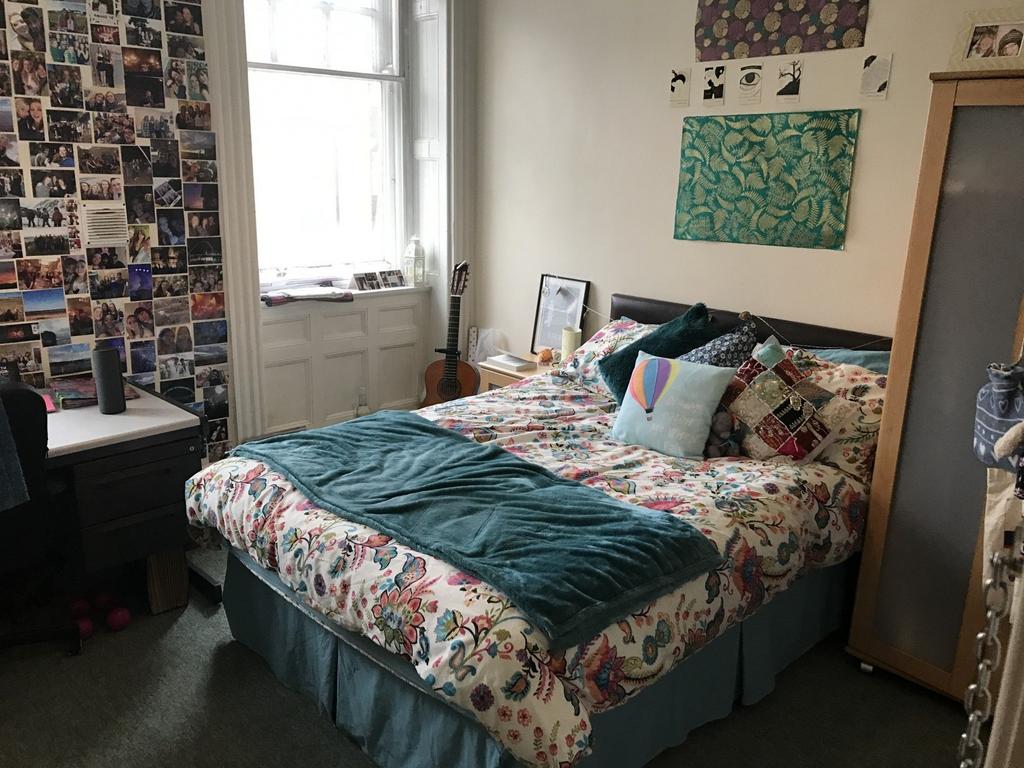Bright, cosy double bedroom with a patterned du...