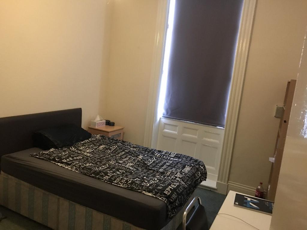 Neat single bedroom with a comfortable bed, bla...