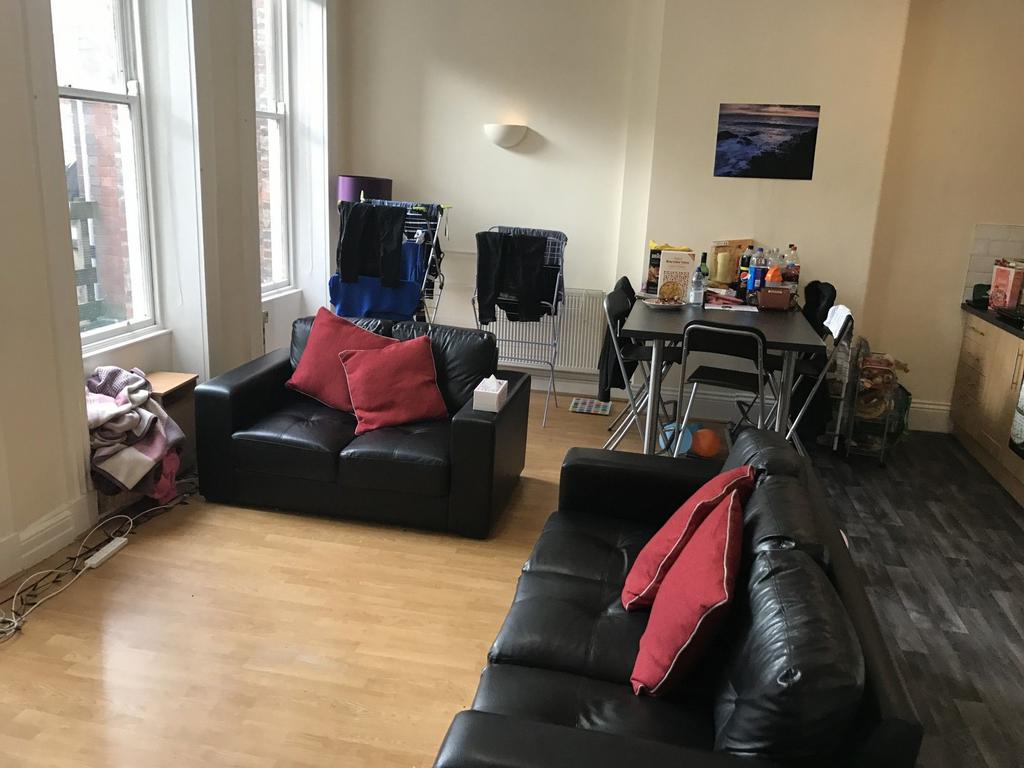 Bright communal living area with large sash win...