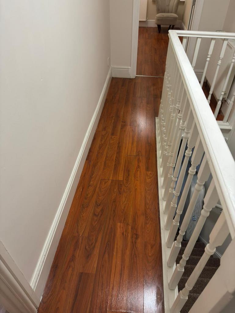 Bright upstairs landing with polished wood-effe...