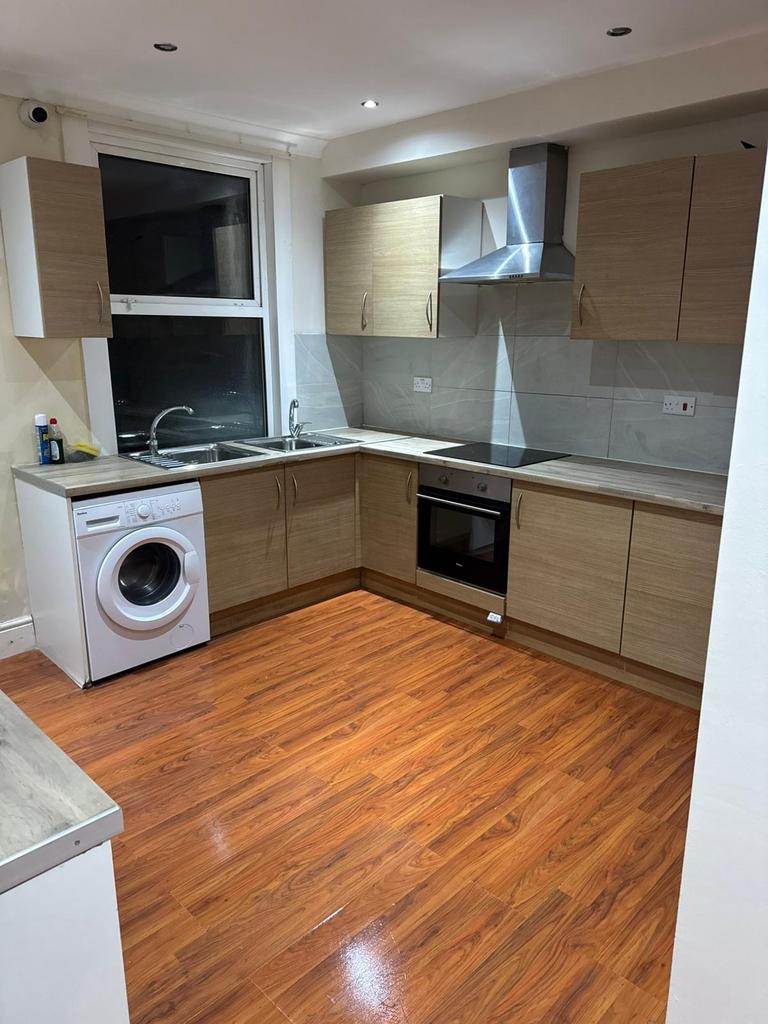 Modern L-shaped kitchen with wood-effect cabine...