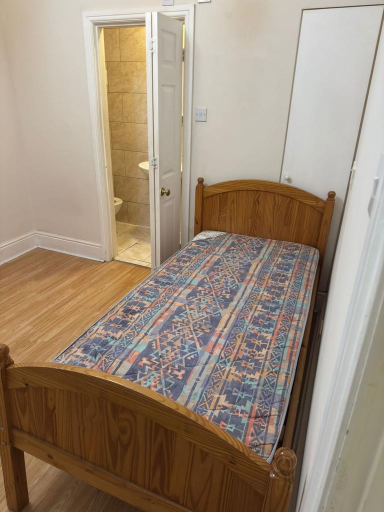 Neat single bedroom with a wooden framed bed, p...