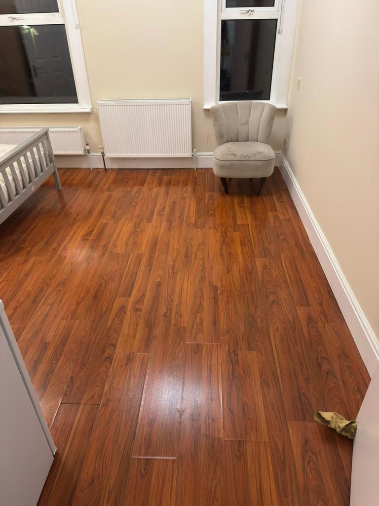 Bright single bedroom with warm wood-effect flo...