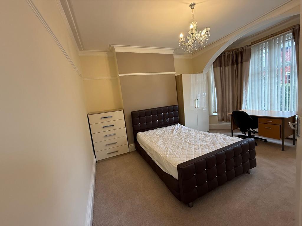 Bright double bedroom with a stylish leather-up...