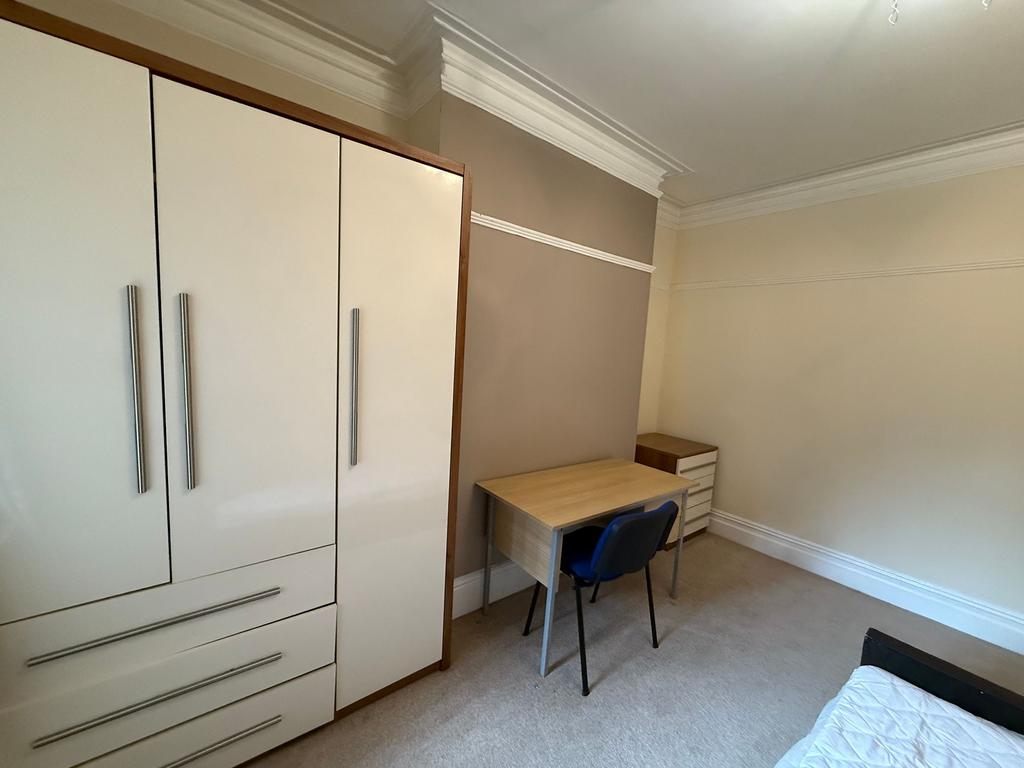Bright, neatly furnished bedroom with built-in ...