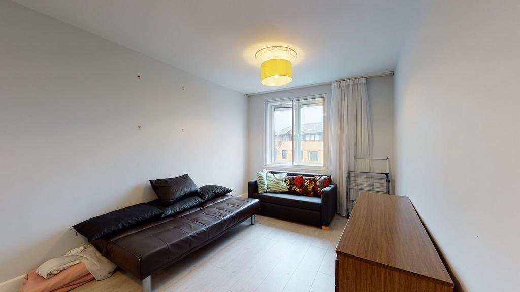 Bright, simply furnished bedroom with a leather...