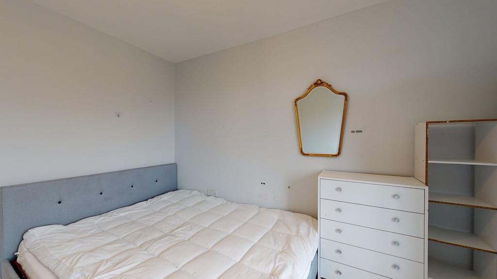 Bright, simply furnished bedroom featuring a co...